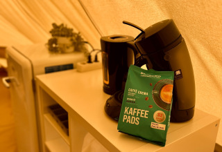 Kaffeemaschine, Kaffeepads und Wasserkocher auf Regal im Tipi-Zelt bei Camp Kyllburg, Deutschland.