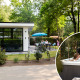 Moderne tiny house kaldet Special Wellness Module (Spa) med have, terrasse og folk i udendørs jacuzzi.