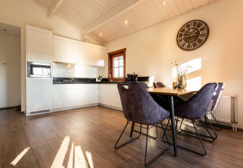 Cocina moderna y comedor en cabaña de madera en Log Cabin II Wellness, Résidence de Leuvert, Países Bajos.