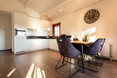 Cocina moderna y comedor en cabaña de madera en Log Cabin II Wellness, Résidence de Leuvert, Países Bajos.