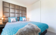Dormitorio moderno en Collosseo Wellness Spa, Résidence Valkenburg, Países Bajos, con ropa de cama azul.