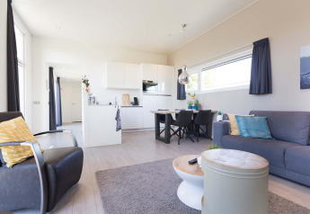 Salón y cocina modernos en Collosseo Wellness (Spa) de Résidence Valkenburg, Países Bajos, decoración luminosa y elegante.