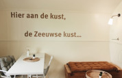 Interior de la cabaña Cocon en 7Huizen aan Zee en los Países Bajos, con texto en neerlandés en la pared.
