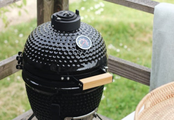 Barbecue in ceramica nera sulla terrazza di legno presso la cabina Cocon, 7Huizen aan Zee, Paesi Bassi.