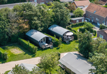 Vista aérea de las cabañas Cocon en 7Huizen aan Zee, Países Bajos, rodeadas de jardines y vegetación.