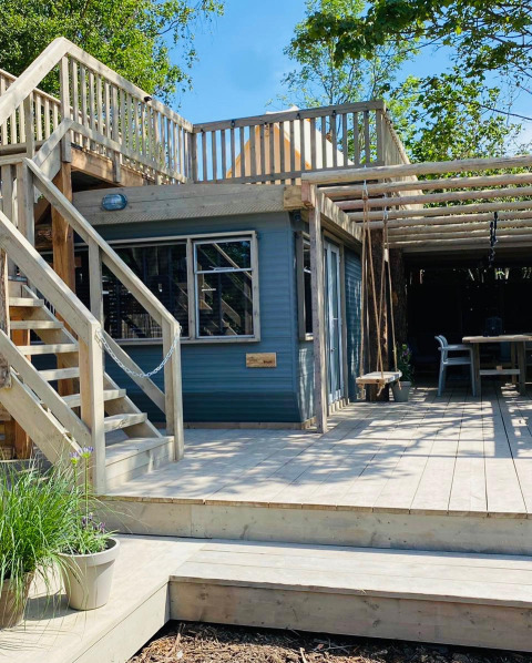 Terraza de madera clara y lodge con escaleras y columpios en Lodge 5, 7Huizen aan Zee, Países Bajos