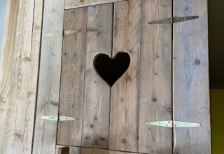 Puerta de madera con recorte en forma de corazón en tienda safari en 7Huizen aan Zee, Países Bajos.