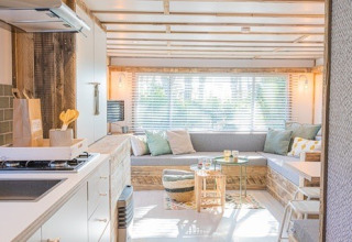 Intérieur de lodge lumineux et moderne avec coin salon et cuisine à Lodge 2 et 3, 7Huizen aan Zee, Pays-Bas.