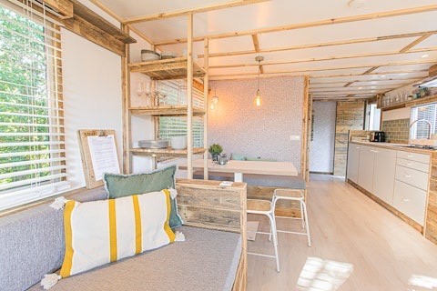 Interior luminoso y moderno de las Lodge 2 y 3 en 7Huizen aan Zee, Países Bajos, con acentos de madera y estilo acogedor.