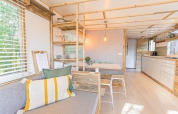 Lyst og moderne interiør af Lodge 2 og 3 hos 7Huizen aan Zee, Holland, med træelementer og hyggelig atmosfære.