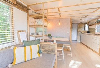 Bright, modern interior of Lodge 2 and 3 at 7Huizen aan Zee, Netherlands, featuring wood accents and cozy design.