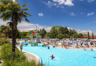 Travl scene ved swimmingpool med vandrutsjebaner og familier på Camping Cisano/San Vito i Veneto, Italien.