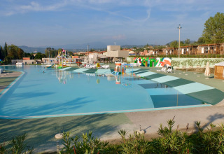 Large swimming pool at Camping Cisano/San Vito holiday park in Veneto, Italy, with loungers and play area.