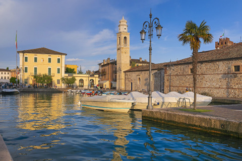 Barcos y edificios históricos en el puerto de Camping Cisano/San Vito, Véneto, Italia en un día soleado.
