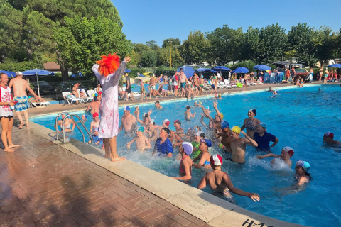 Niños jugando en una piscina del camping Cisano/San Vito en Veneto, Italia, durante un día soleado.