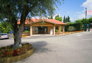 Receptionen på Camping Cisano/San Vito feriepark i Veneto, Italien, omgivet af blomster og grønne områder.