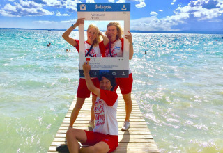 Trois amis posent avec un cadre Instagram sur un ponton au Camping Cisano/San Vito, Vénétie, Italie.