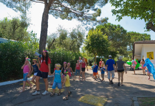 Børn og voksne hygger sig i solen på Camping Cisano/San Vito feriepark i Veneto, Italien.