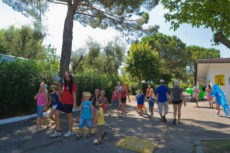 Children and adults enjoy a sunny day at Camping Cisano/San Vito holiday park in Veneto, Italy.