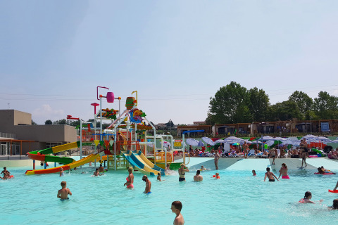 Kinderen spelen in een zwembad met kleurrijke glijbanen op Camping Cisano/San Vito in Veneto, Italië.
