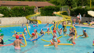 Children playing with pool noodles and slides at Camping Cisano/San Vito holiday park in Veneto, Italy.