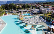 Vista aerea del Camping Cisano/San Vito in Veneto, Italia, con piscine, lettini e panorama sulle colline.