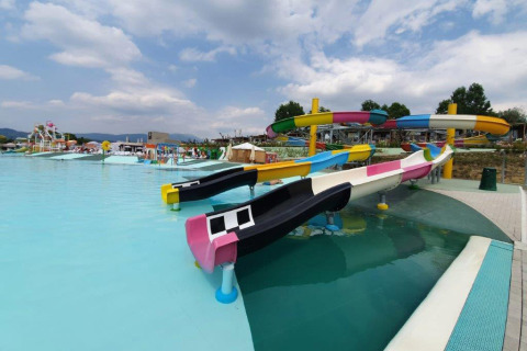 Parque acuático en Camping Cisano/San Vito, Véneto, Italia, con toboganes de colores y una gran piscina.
