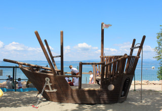 Parco giochi con nave pirata in legno sulla spiaggia di Camping Cisano/San Vito, Veneto, Italia.
