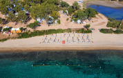 Aerial view of Camping Gasparina in Veneto, Italy, featuring a sandy beach, umbrellas, loungers and clear water.