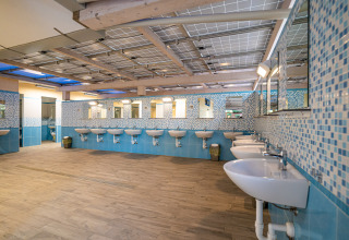 Large, modern bathroom with multiple sinks and mirrors at Camping Gasparina, Veneto, Italy.