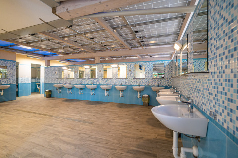 Baño amplio y moderno con varios lavabos y espejos en Camping Gasparina, Véneto, Italia.