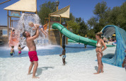 Families enjoy a sunny day at the water playground in Camping Pra'delle Torri holiday park in Veneto, Italy.