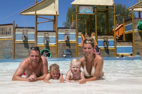 Una familia disfruta de un día soleado en la piscina de Camping Pra'delle Torri en Veneto, Italia.