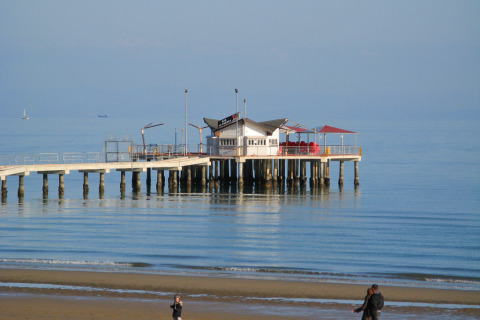 Vista de un muelle con restaurante en el mar en Camping Pra'delle Torri, Véneto, Italia, en un día tranquilo.