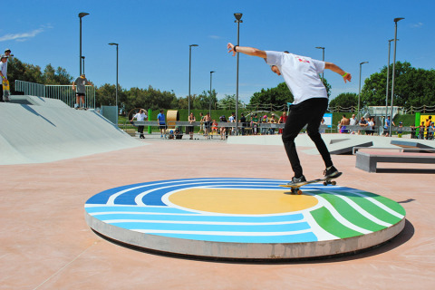 Skater haciendo un truco sobre una rampa circular colorida en el skatepark de Camping Pra'delle Torri en Véneto.