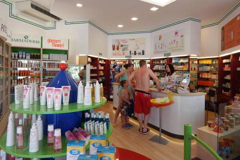 Una familia compra en una farmacia con productos solares en Camping Pra'delle Torri, Véneto, Italia.