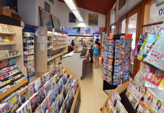 Interiør af kiosken på Camping Pra'delle Torri, Veneto, Italien, med blade, magasiner og kunder.