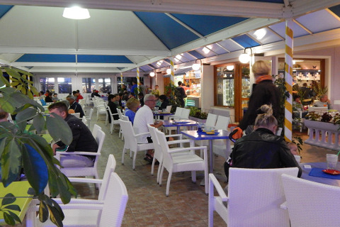 Comensales disfrutan de una comida en el área cubierta de Camping Pra'delle Torri en Véneto, Italia.