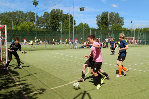 Young people play football outdoors on a pitch at Camping Pra'delle Torri holiday park in Veneto, Italy.