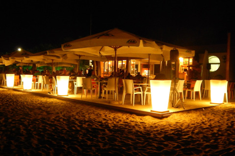 Outdoor dining area at Camping Pra'delle Torri, Veneto, Italy, brightly lit with large lamps at night.