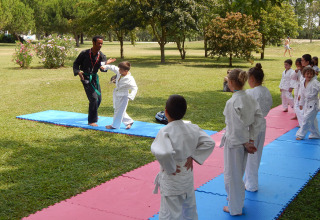 Children practicing martial arts outdoors at Camping Pra'delle Torri holiday park, Veneto, Italy.
