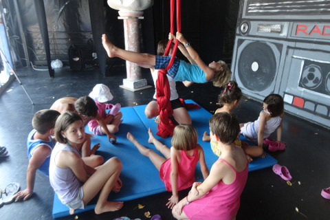 Bambini partecipano ad acrobazie e giochi aerei su tappetini al Camping Pra'delle Torri, Veneto, Italia.