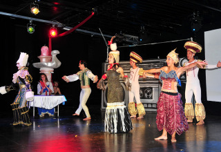 Actores con disfraces coloridos actúan en un escenario durante un espectáculo en Camping Pra'delle Torri, Véneto, Italia.