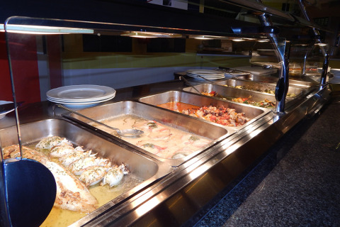 Buffet con platos calientes en el parque vacacional Camping Pra'delle Torri en Véneto, Italia.