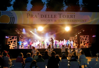Avondshow en entertainment op buitenpodium op Camping Pra'delle Torri in Veneto, Italië, met toeschouwers.