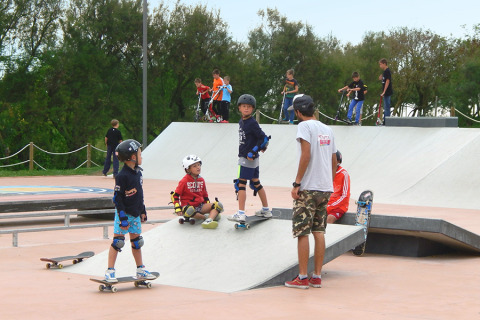 Children and teens learn skateboarding and scootering at a skatepark at Camping Pra'delle Torri, Veneto, Italy.