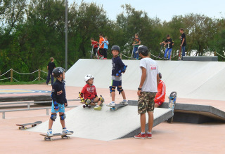 Children and teens learn skateboarding and scootering at a skatepark at Camping Pra'delle Torri, Veneto, Italy.