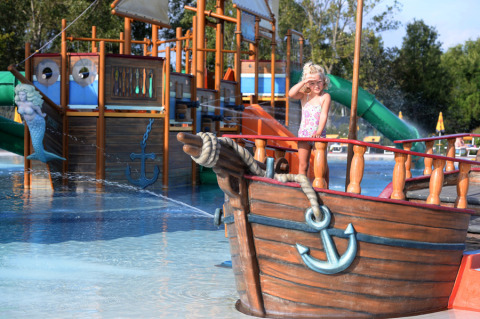 Child plays on a pirate ship in the water park at Camping Pra'delle Torri holiday park in Veneto, Italy.