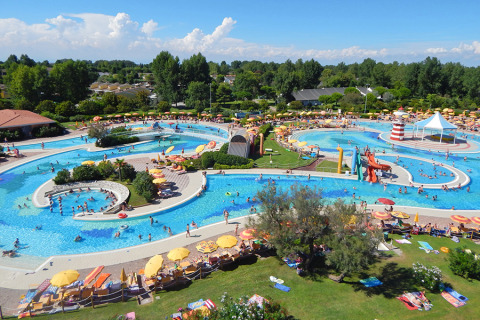 Luchtbeeld van het waterpark op Camping Pra'delle Torri met zwembaden, glijbanen en ligstoelen.