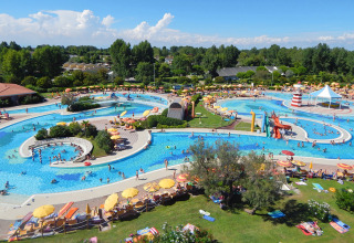 Luftfoto af det farverige vandland på Camping Pra'delle Torri med pools, rutsjebaner og solsenge.